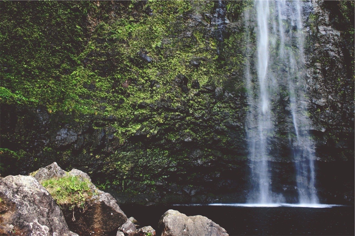 a large waterfall next to a rock
