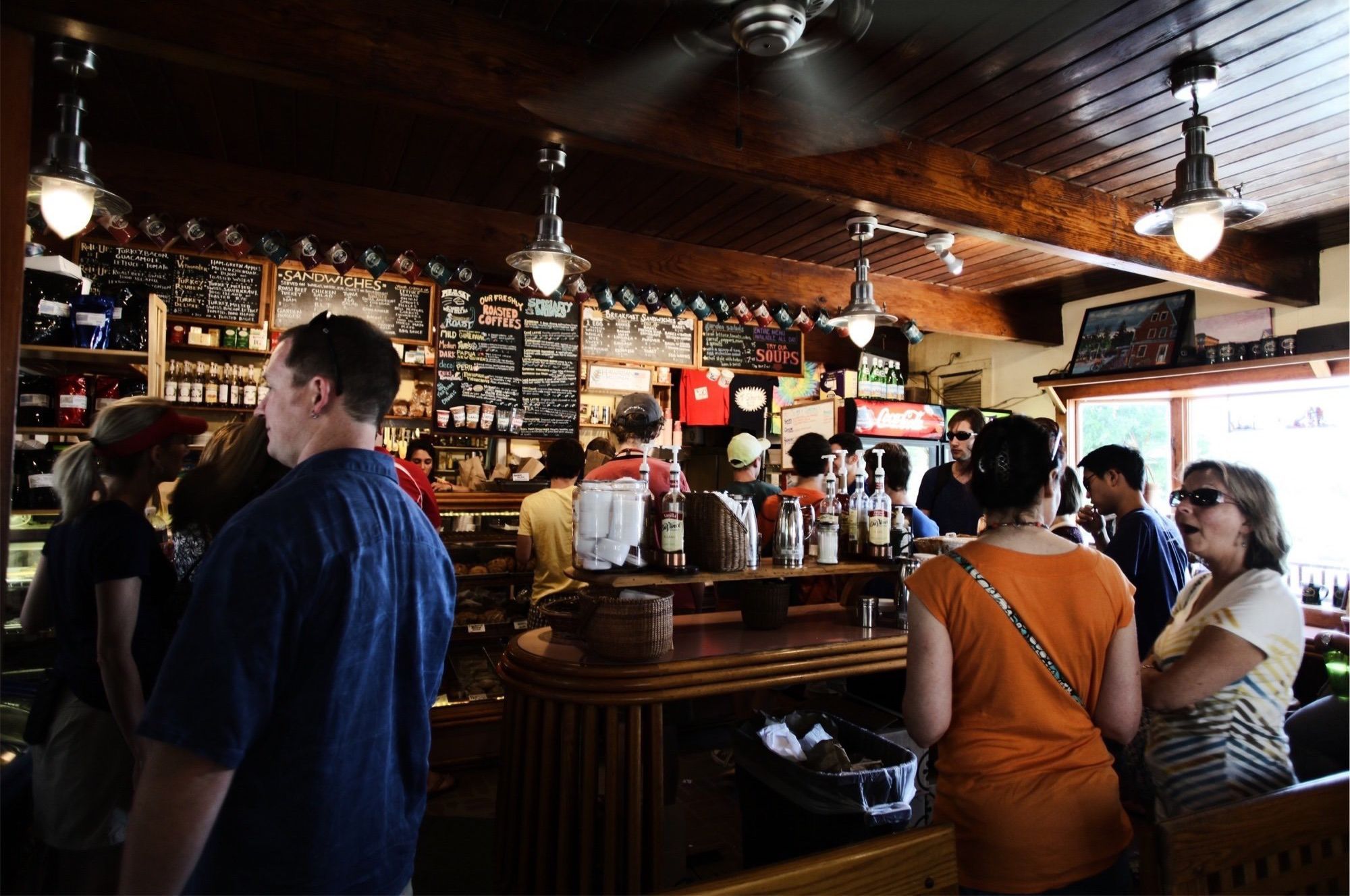 a group of people standing around a counter in a bar